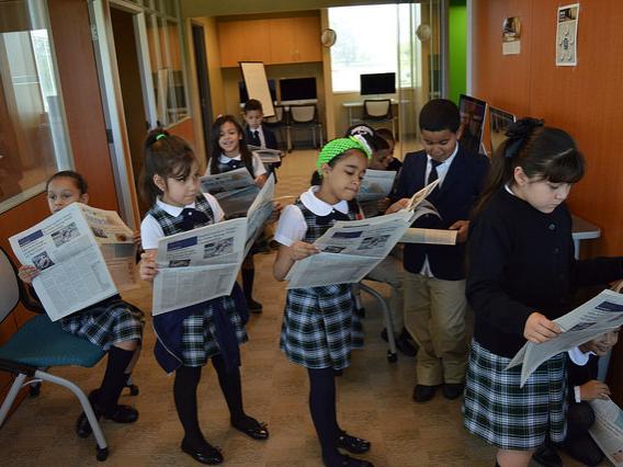 group of students reading newspapers