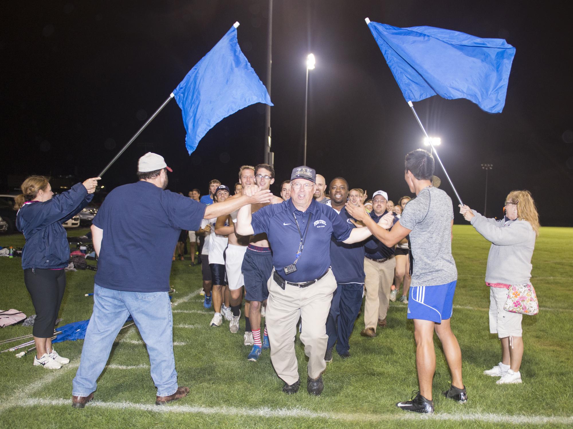 Director Richard Bundy leads a long train of students in a lap around the practice field.