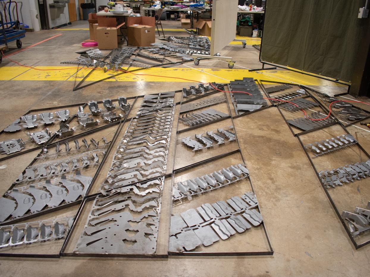 Auto scrap pans laid out on a floor to make up the walls of the chapel.