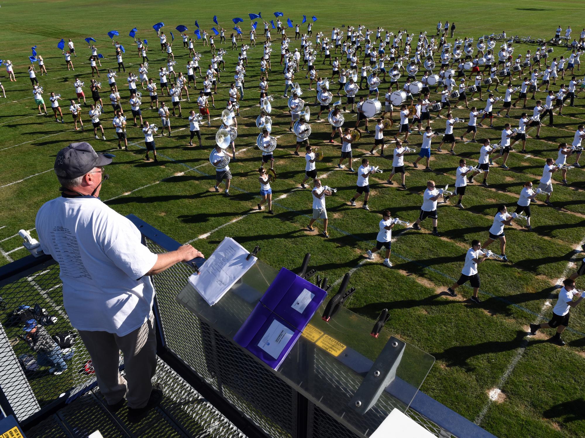 Richard Bundy directs the Blue Band from atop the tower that gives him a full vantage point of the practice field.