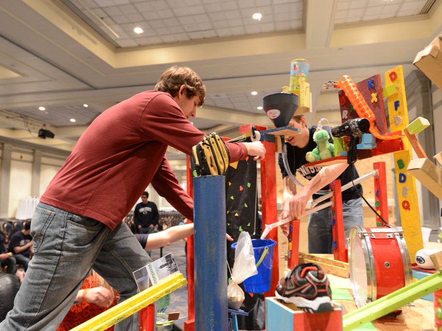 Student makes adjustment to Rube Goldberg machine
