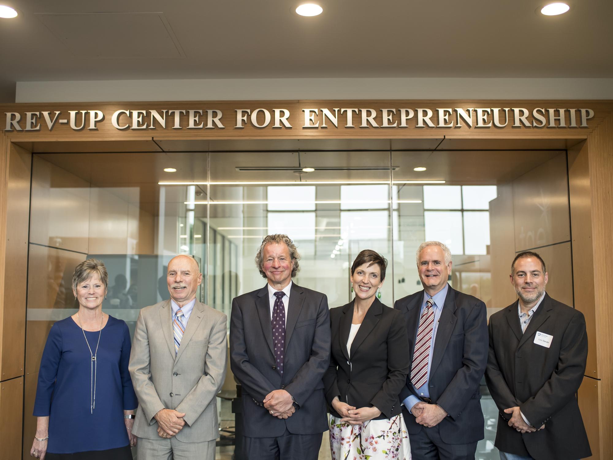 Marybeth DiVincenzo, Neil Sharkey, James Nemes, Nena Ellis Koschny, Doug Schumer, and Leo Daiuto, stand in front of the REV-UP Center for Entrepreneurship.