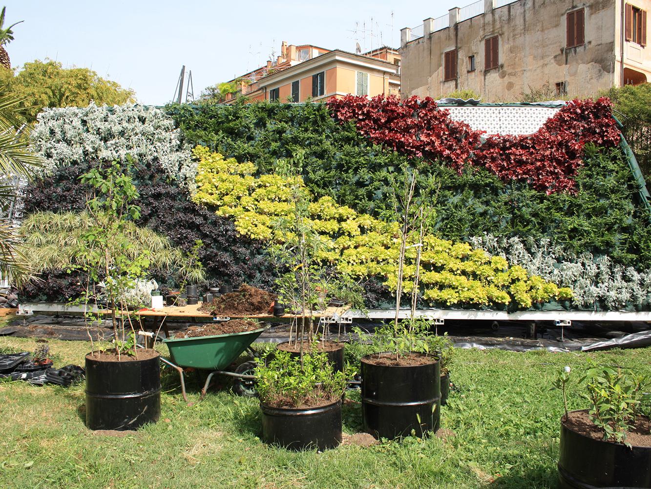 Various plants are on one of the green walls in a mosaic pattern.