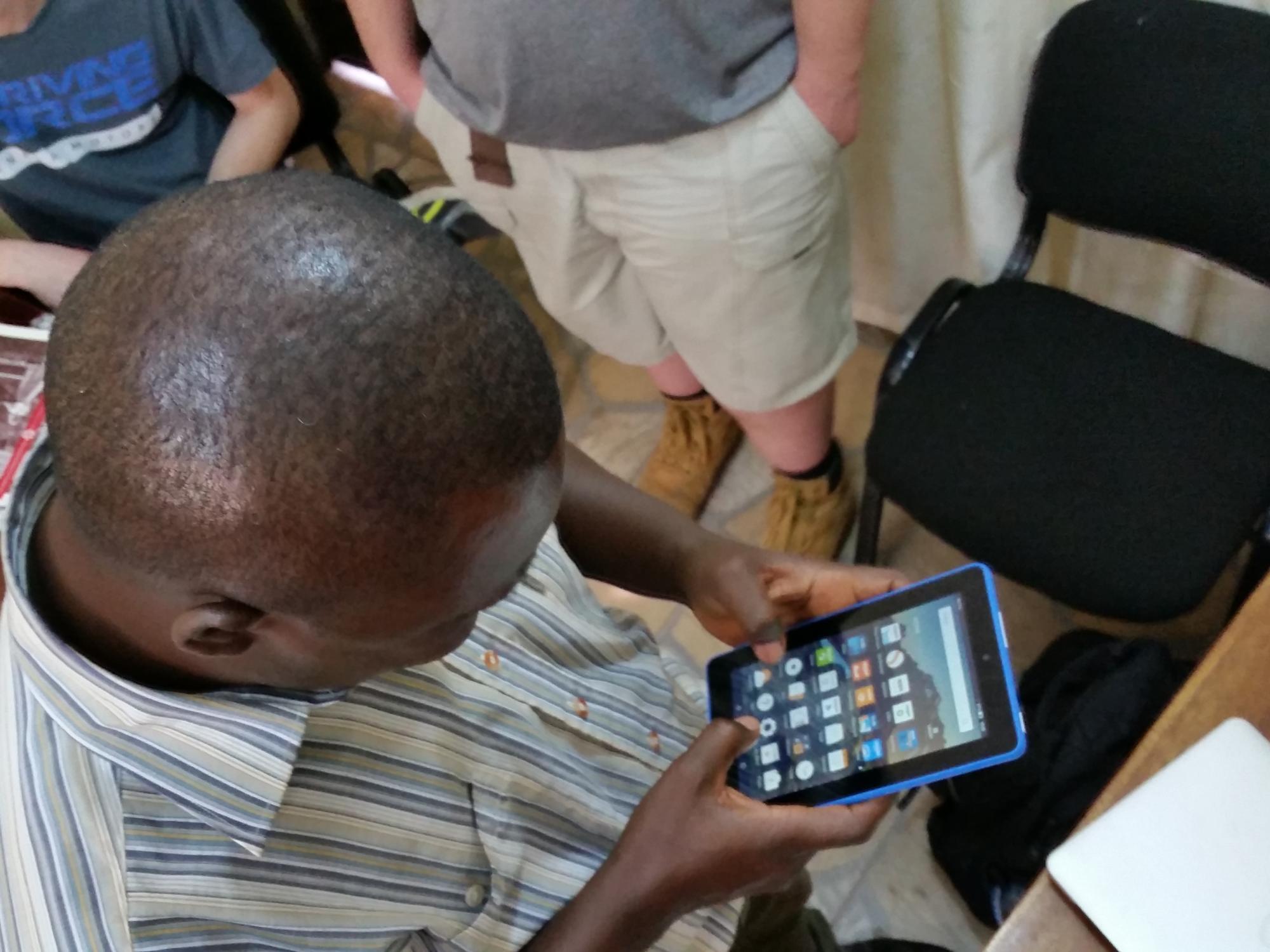 A farmer looks at the manual on the tablet. 