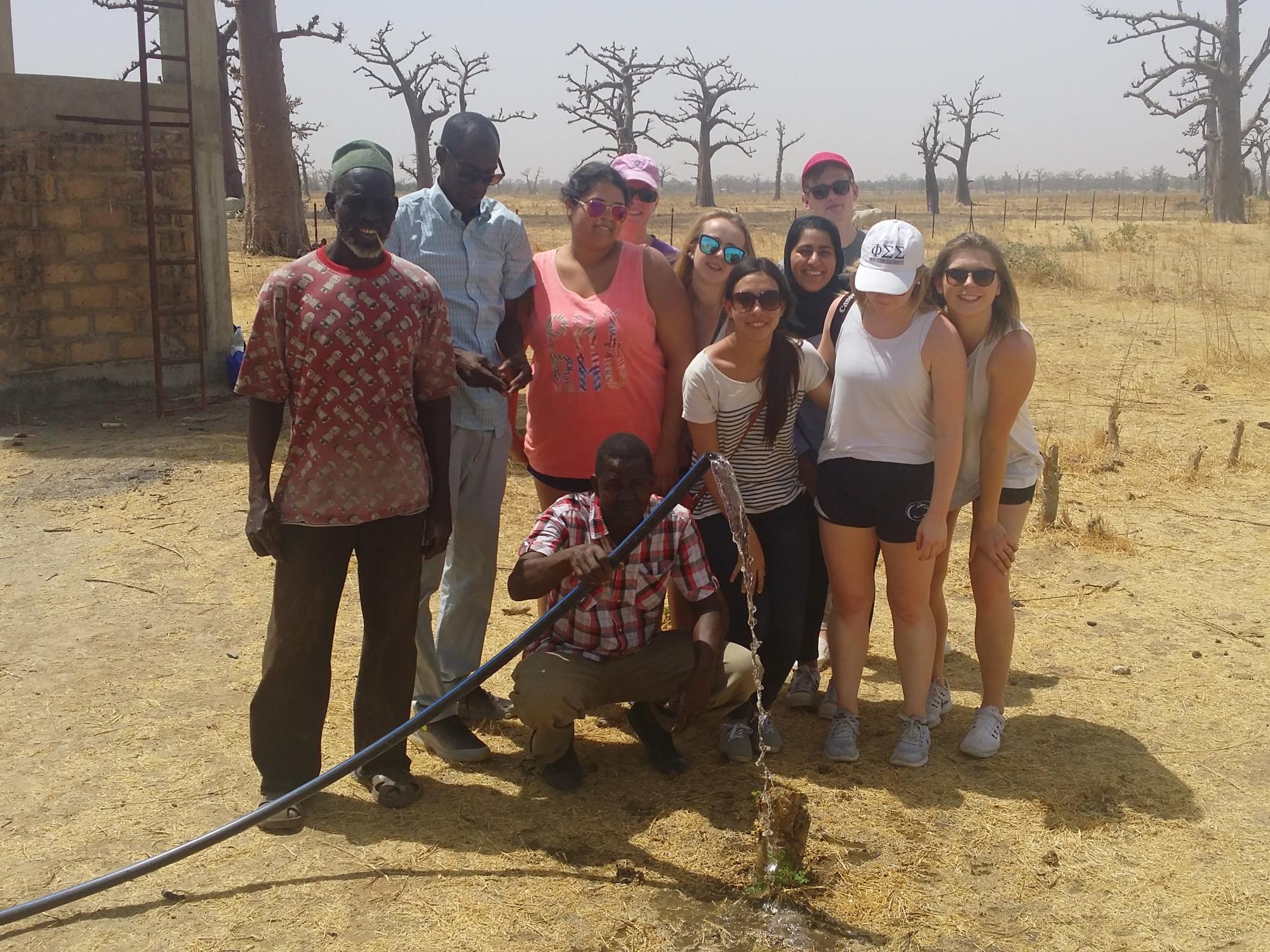 ELD students pose with a solar-powered water pump