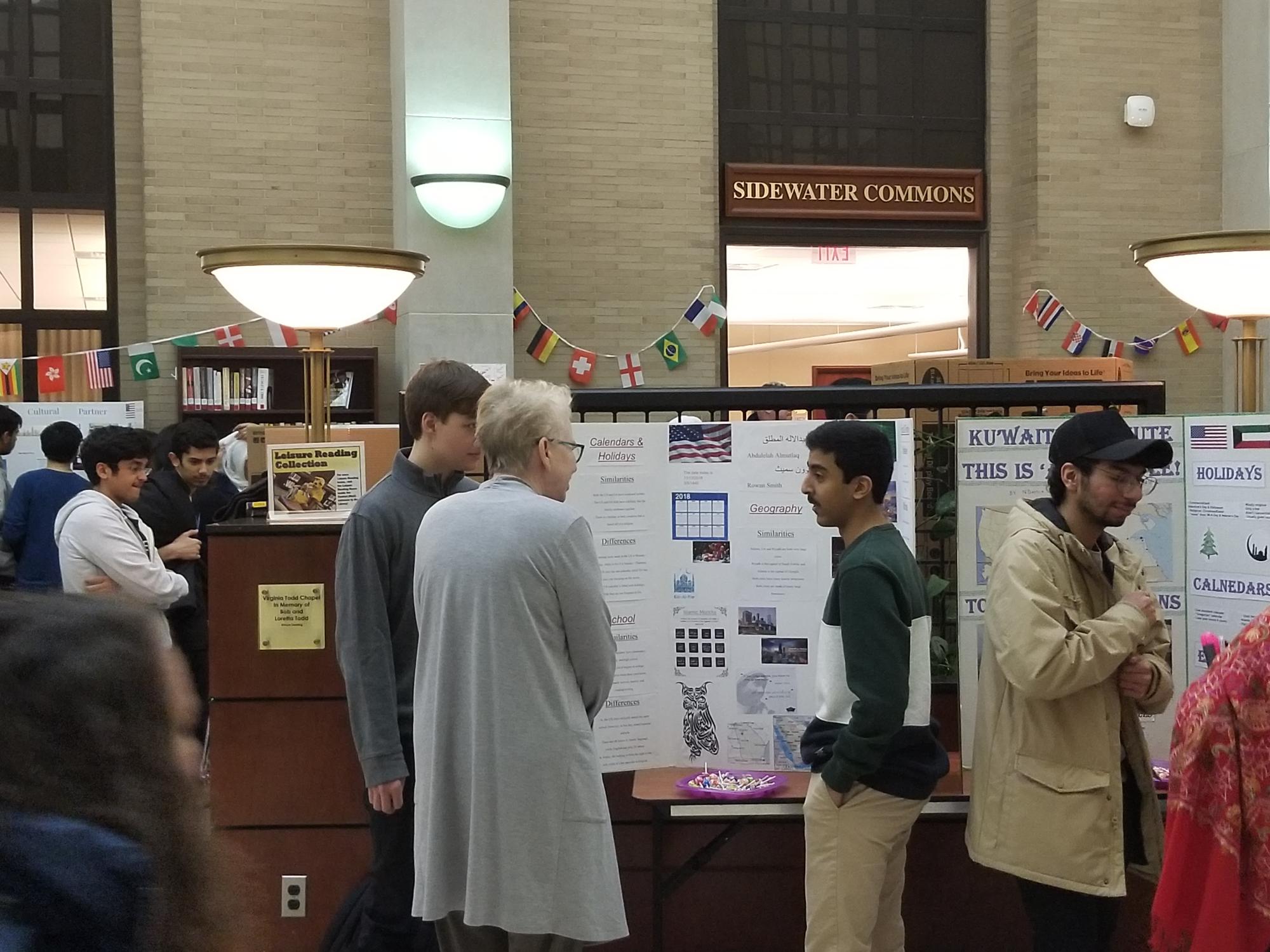 Dean Barbara Dewey standing with students in front of a poster presentation