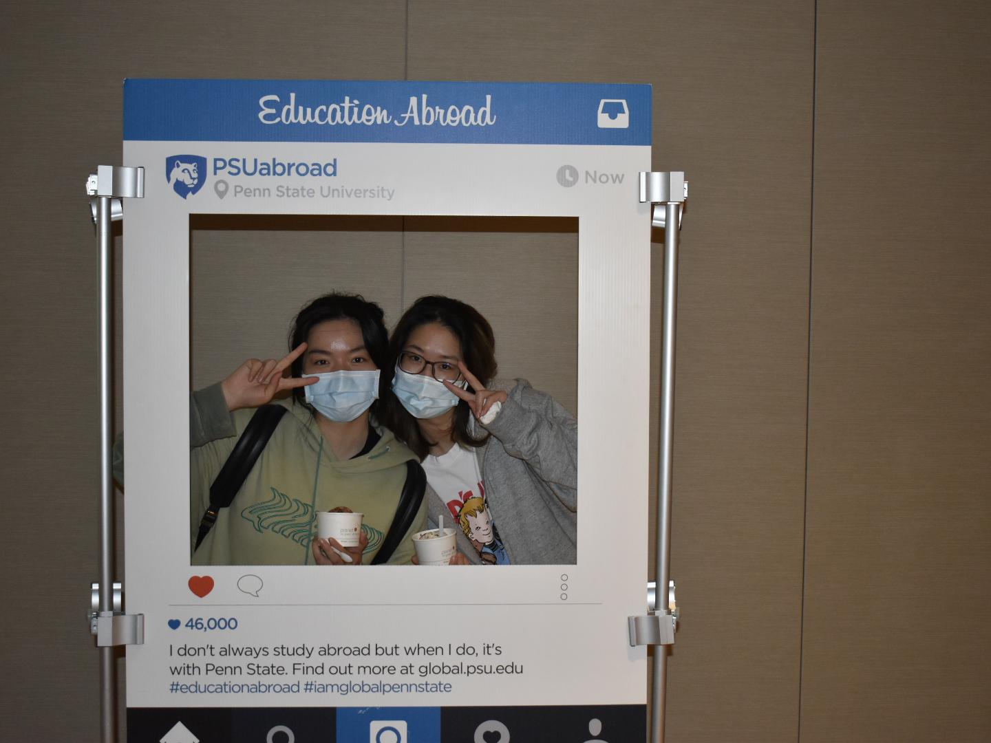 Two students posing inside of an Instagram-style cutout