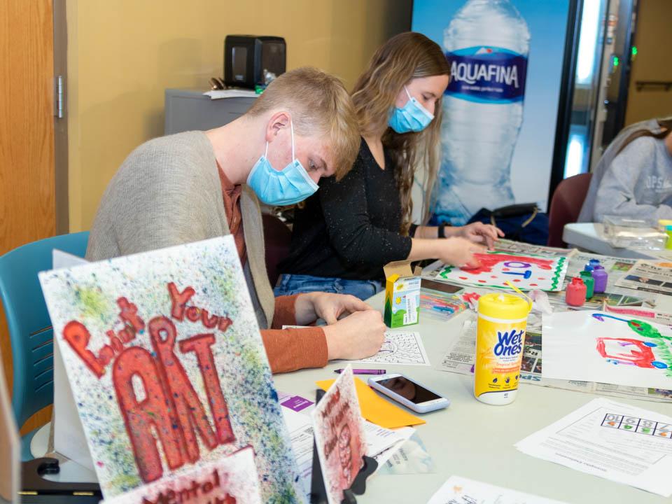 Three students doing crafts at a table