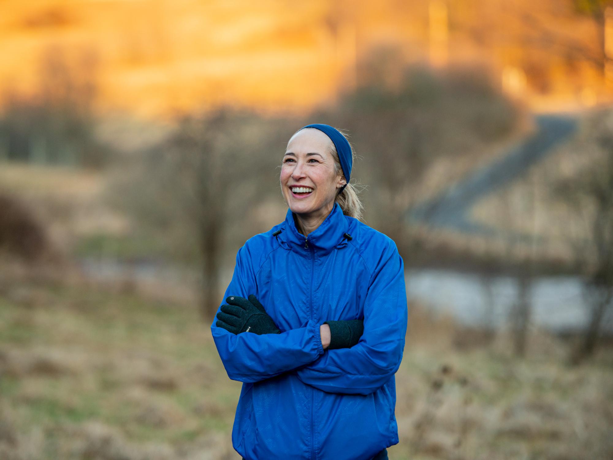 Marie Hardin, dean of the Bellisario College of Communications, smiles while wearing running gear and being surrounded by nature.
