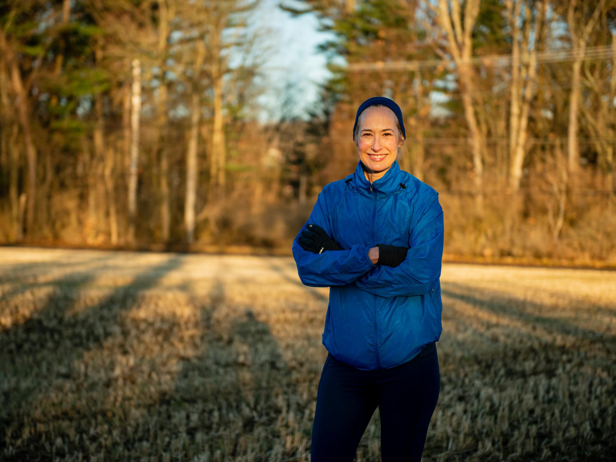 Marie Hardin, dean of the Bellisario College of Communications, smiles while wearing running gear and being surrounded by nature.