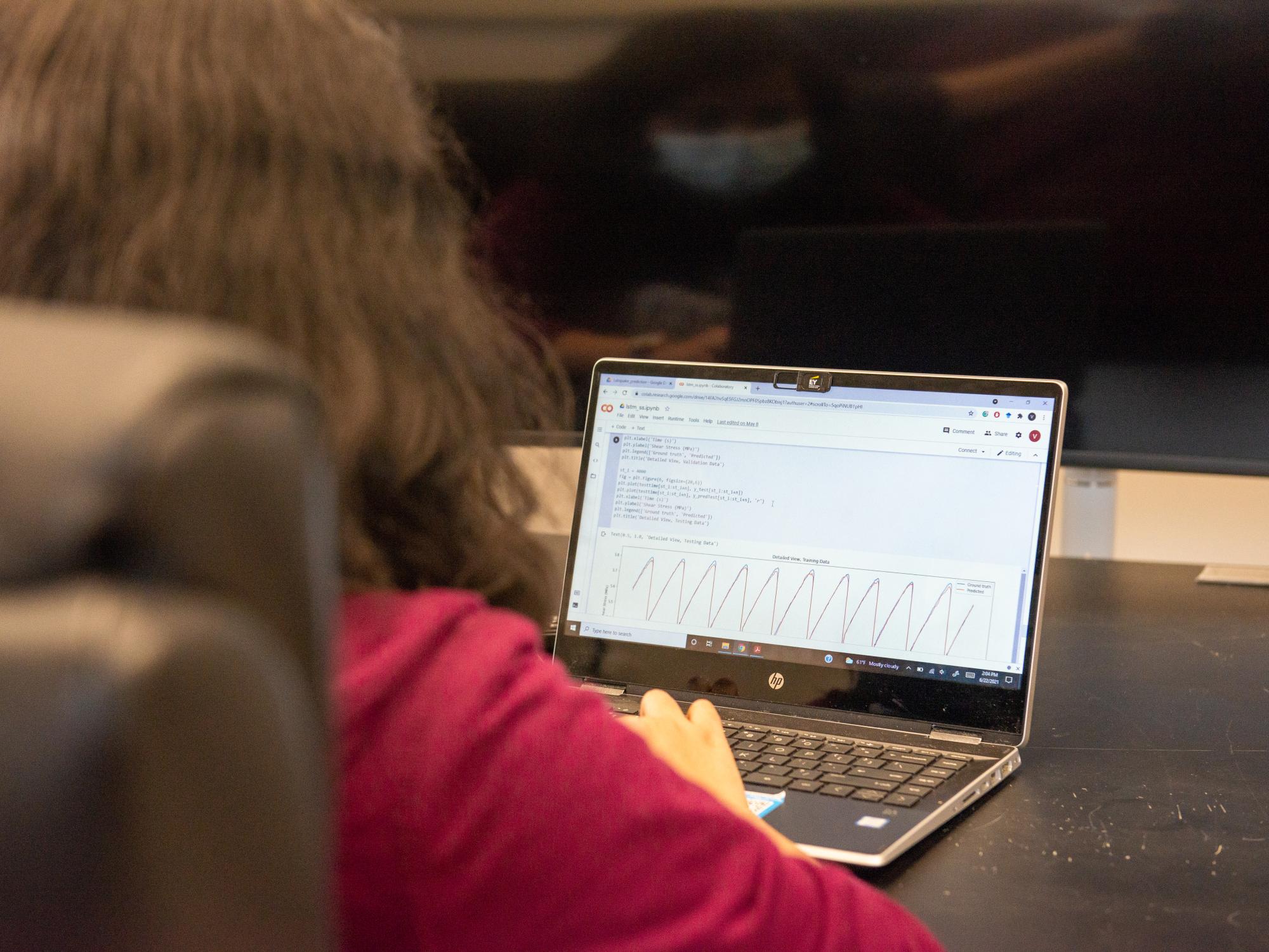 student sitting at desk working on laptop