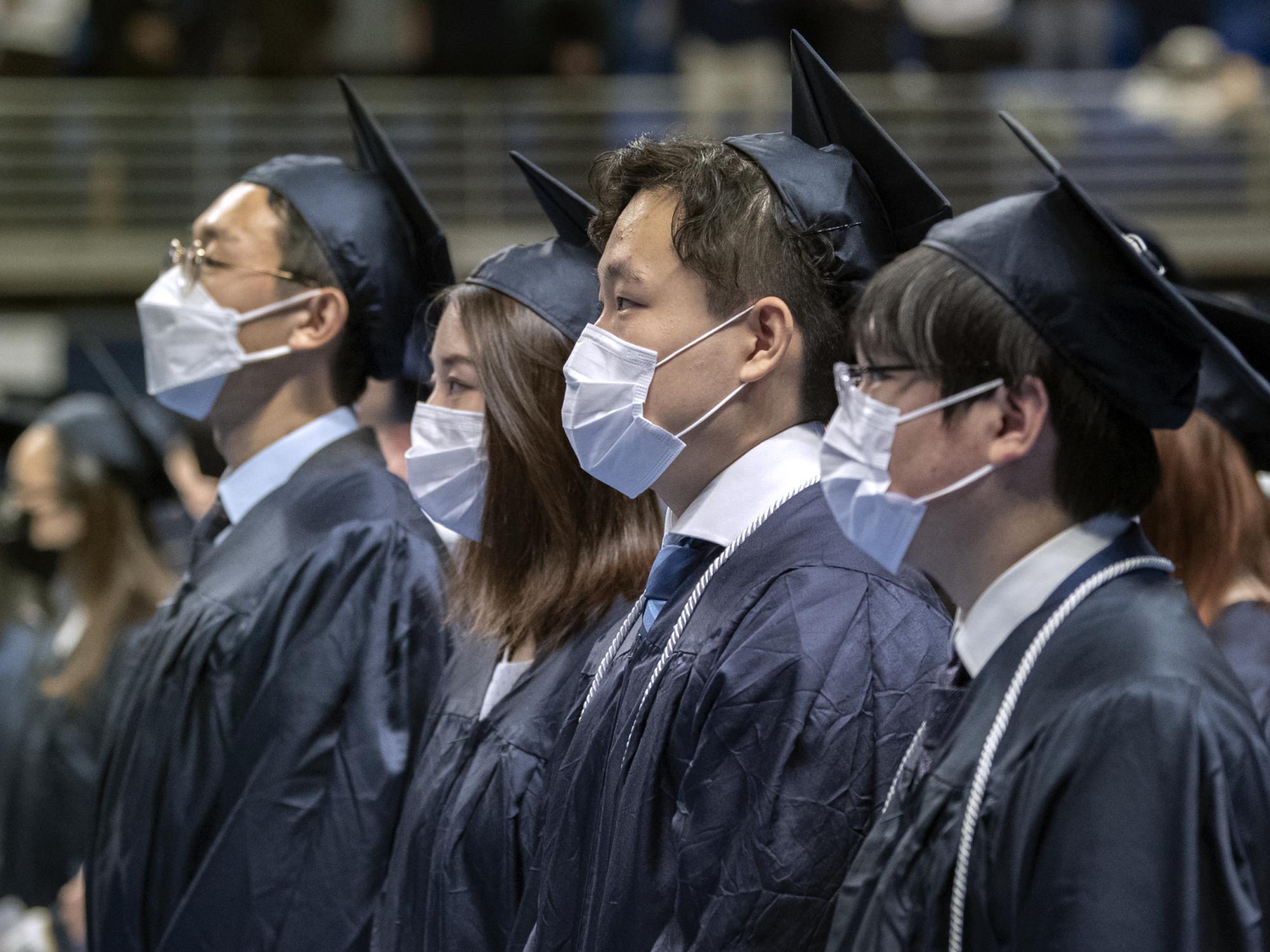 graduates rise during grand procession