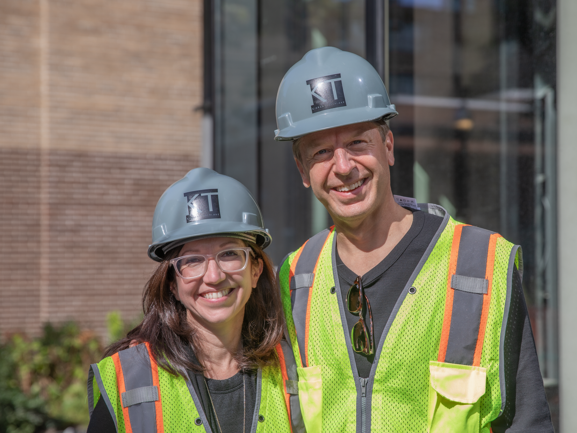 Marilia Rodrigues and Jason E. Smith pictured in hardhats and safety vests.