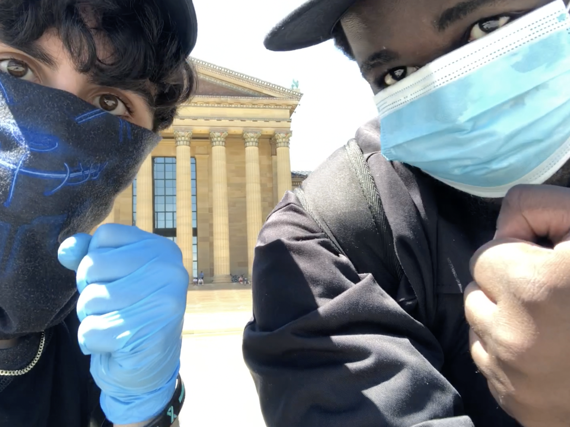 Filmmaker Jacob Mejias sits with friend Joshua Yeboah-Gyasi  in front of the Philadelphia Art Museum. 