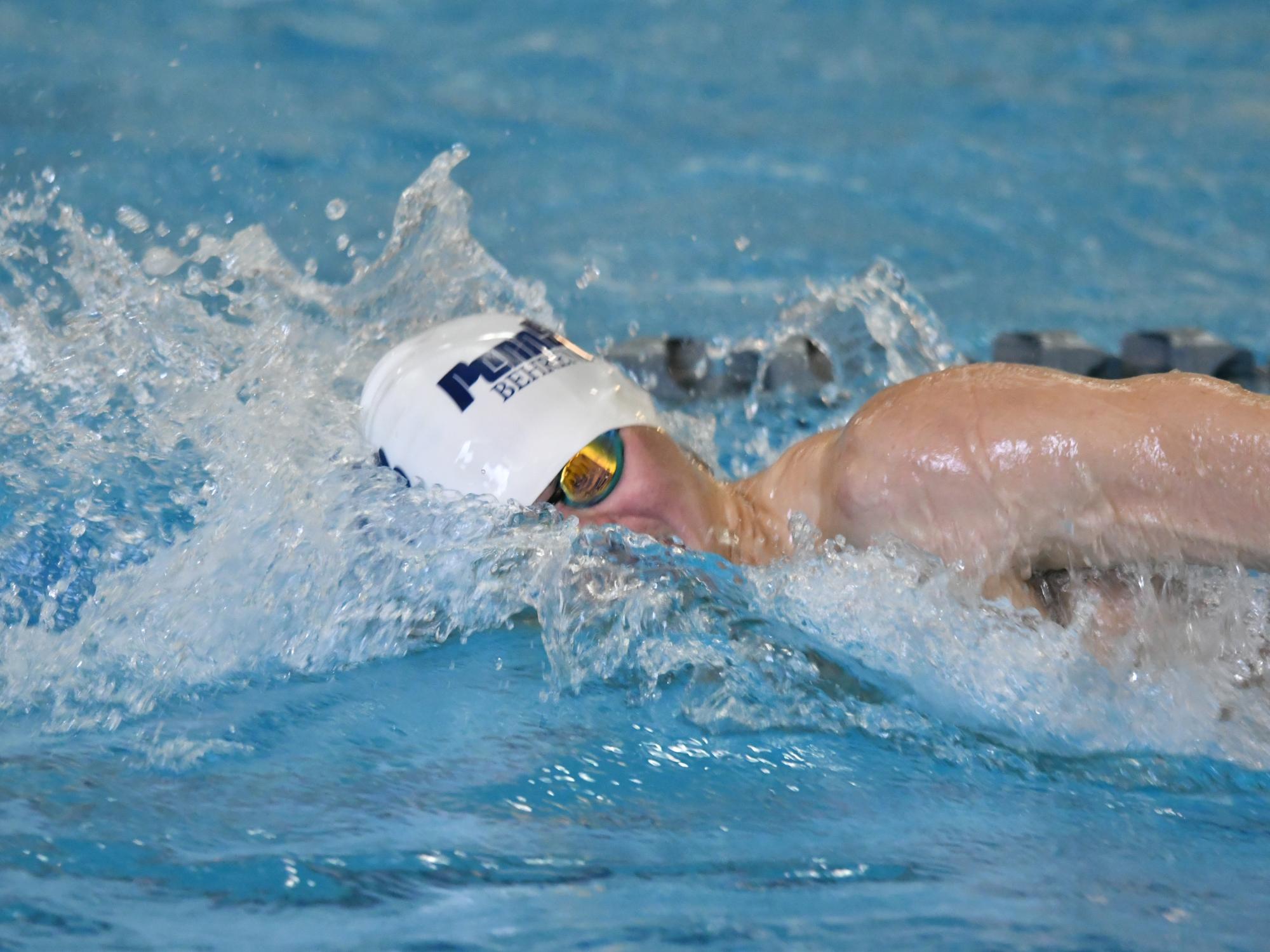 A Penn State Behrend swimmer competes in a freestyle race.