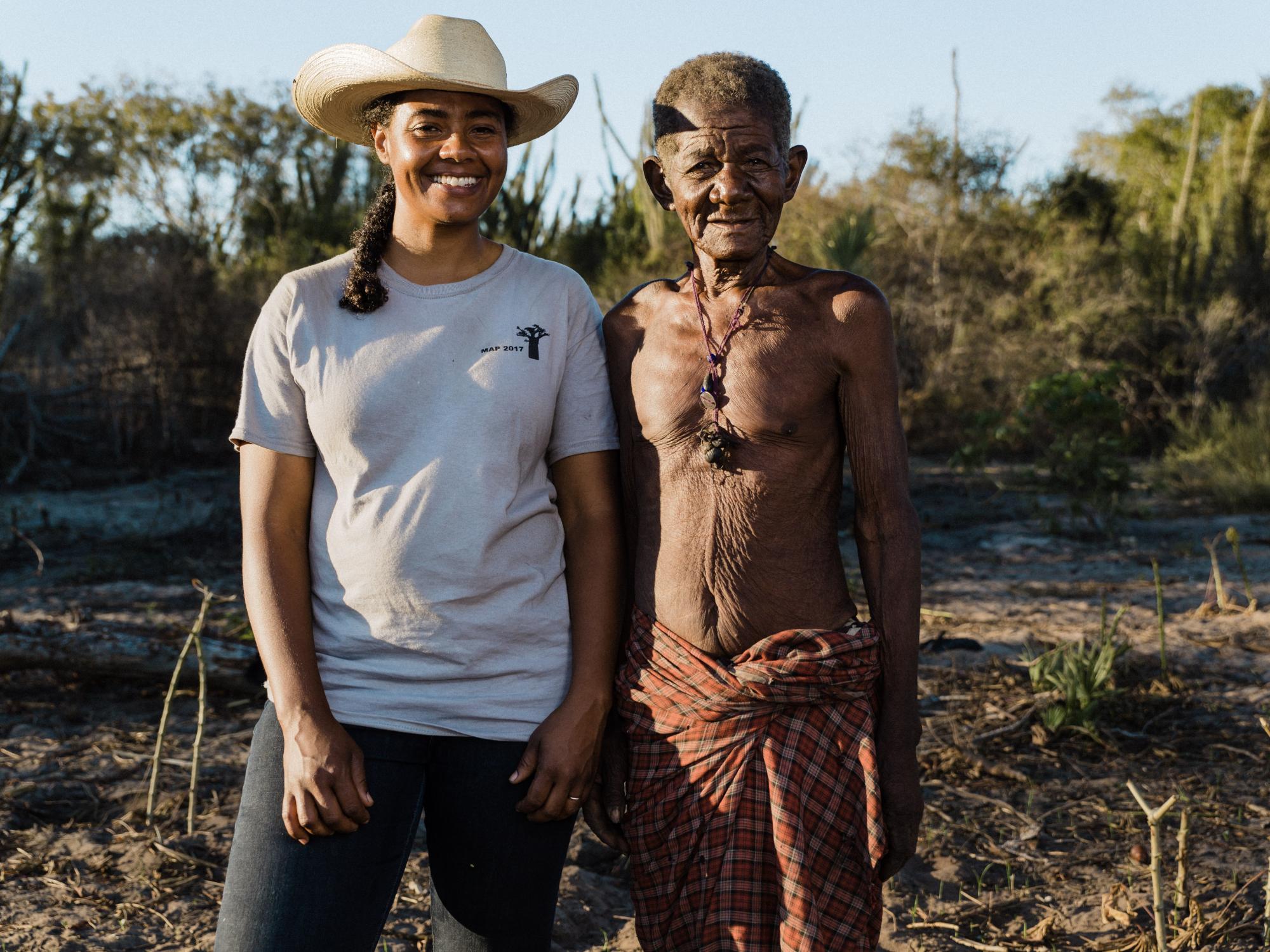 Two researchers in field smile for camera
