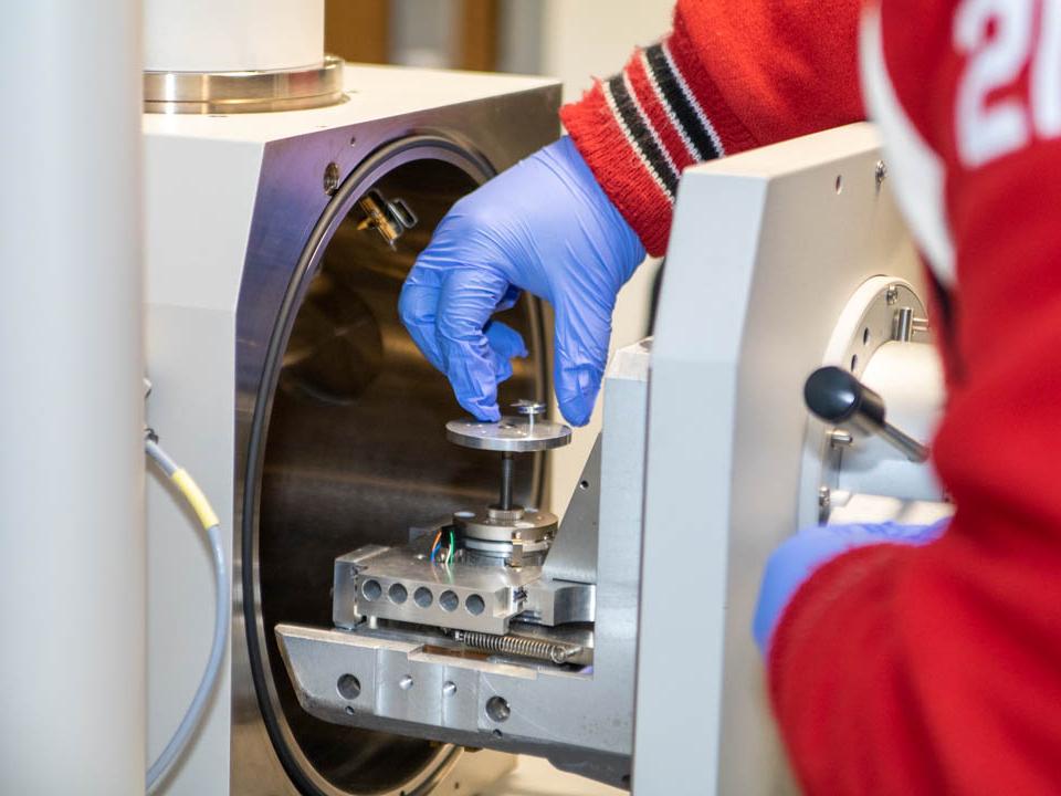 Student placing mask sample in SEM machine 