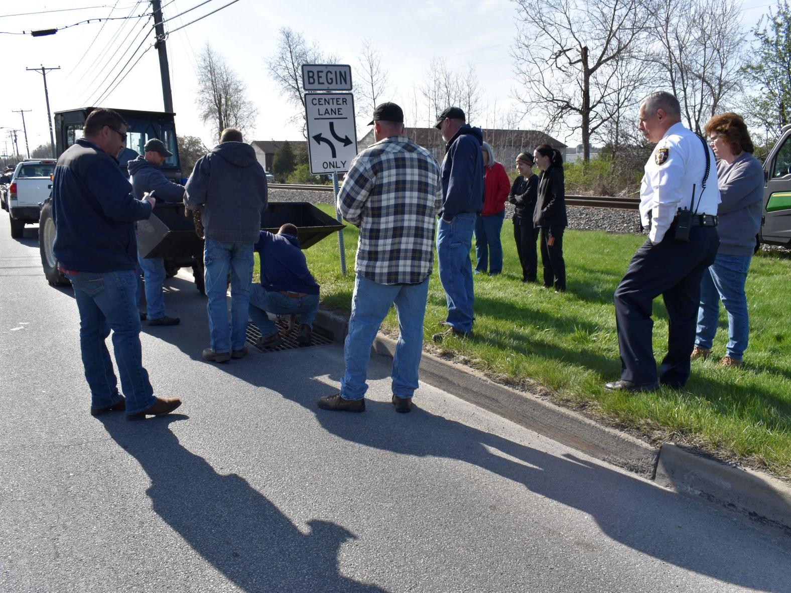 Members of the DuBois community working together to safely rescue ducklings from a storm drain.
