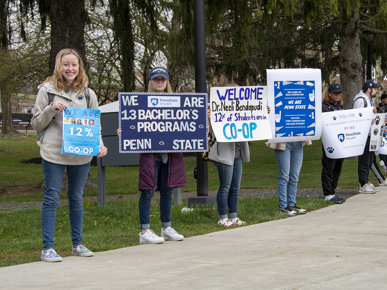 Students standing outdoors holding signs with Penn State Schuylkill facts