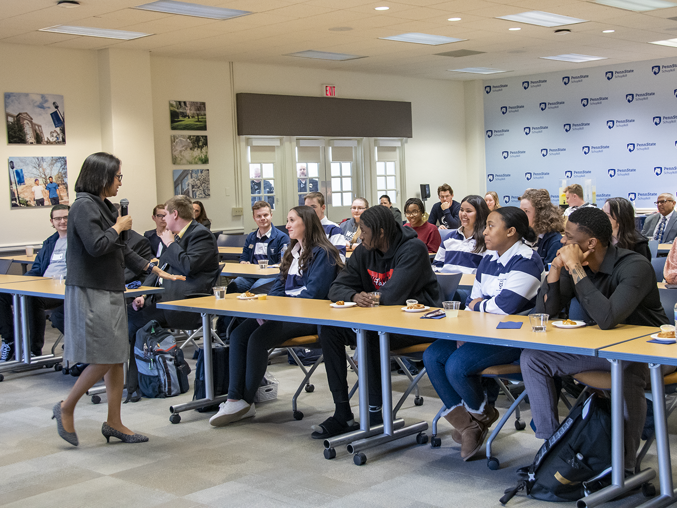 Woman with microphone speaks to classroom full of students