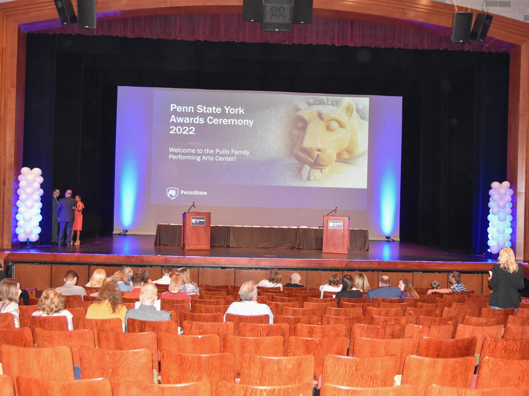 Theatre stage with podiums and balloons.
