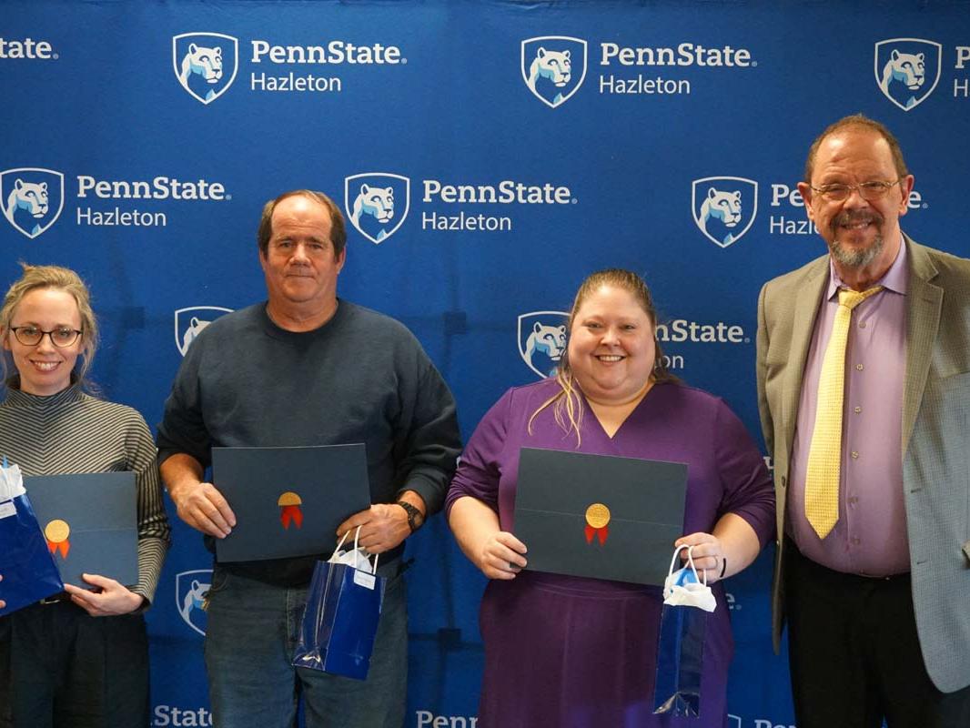 Group standing in a row with certificate holders.