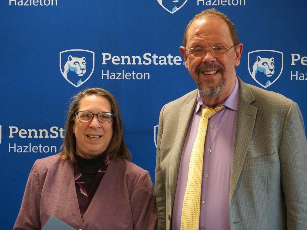 Woman and man standing side by side smiling.