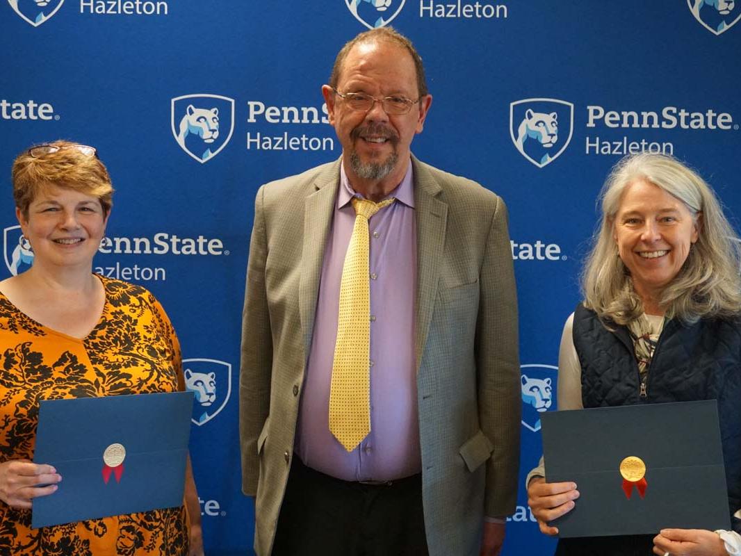 Group holding certificates and smiling.
