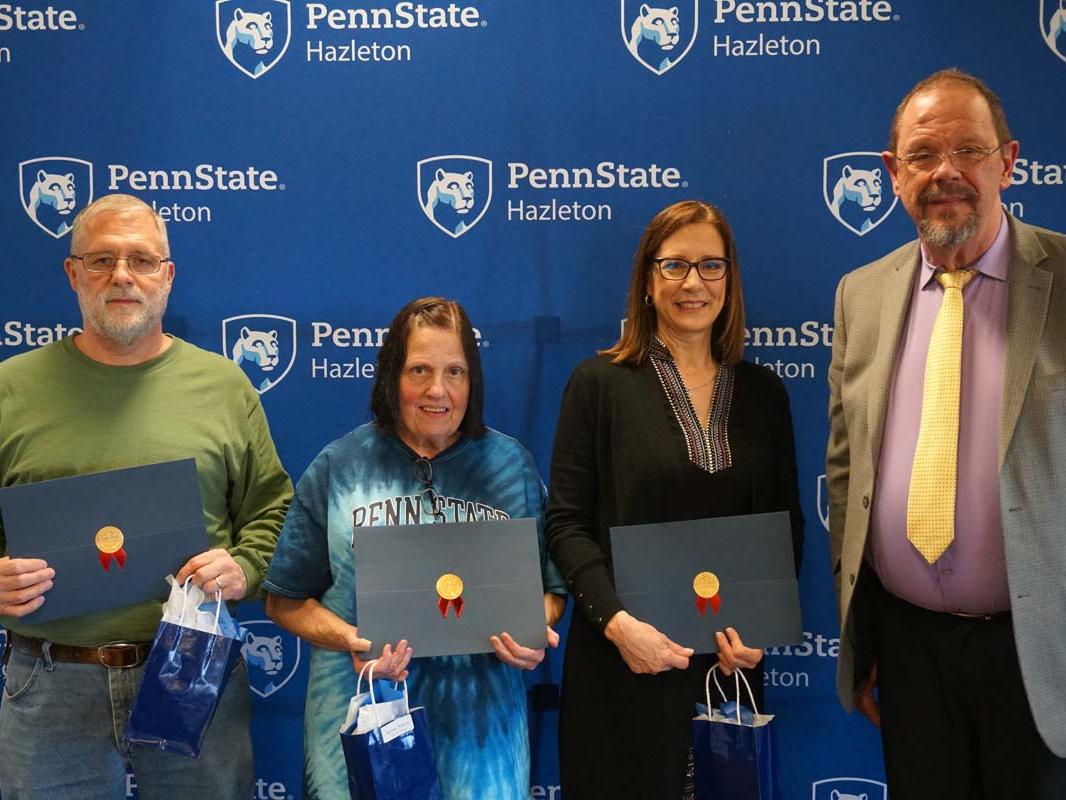 Group holding certificates and smiling.