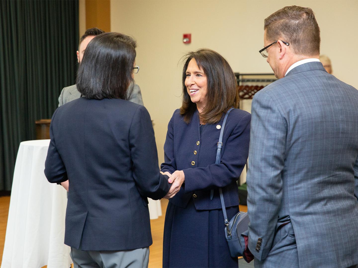 Individual shaking hands with another person