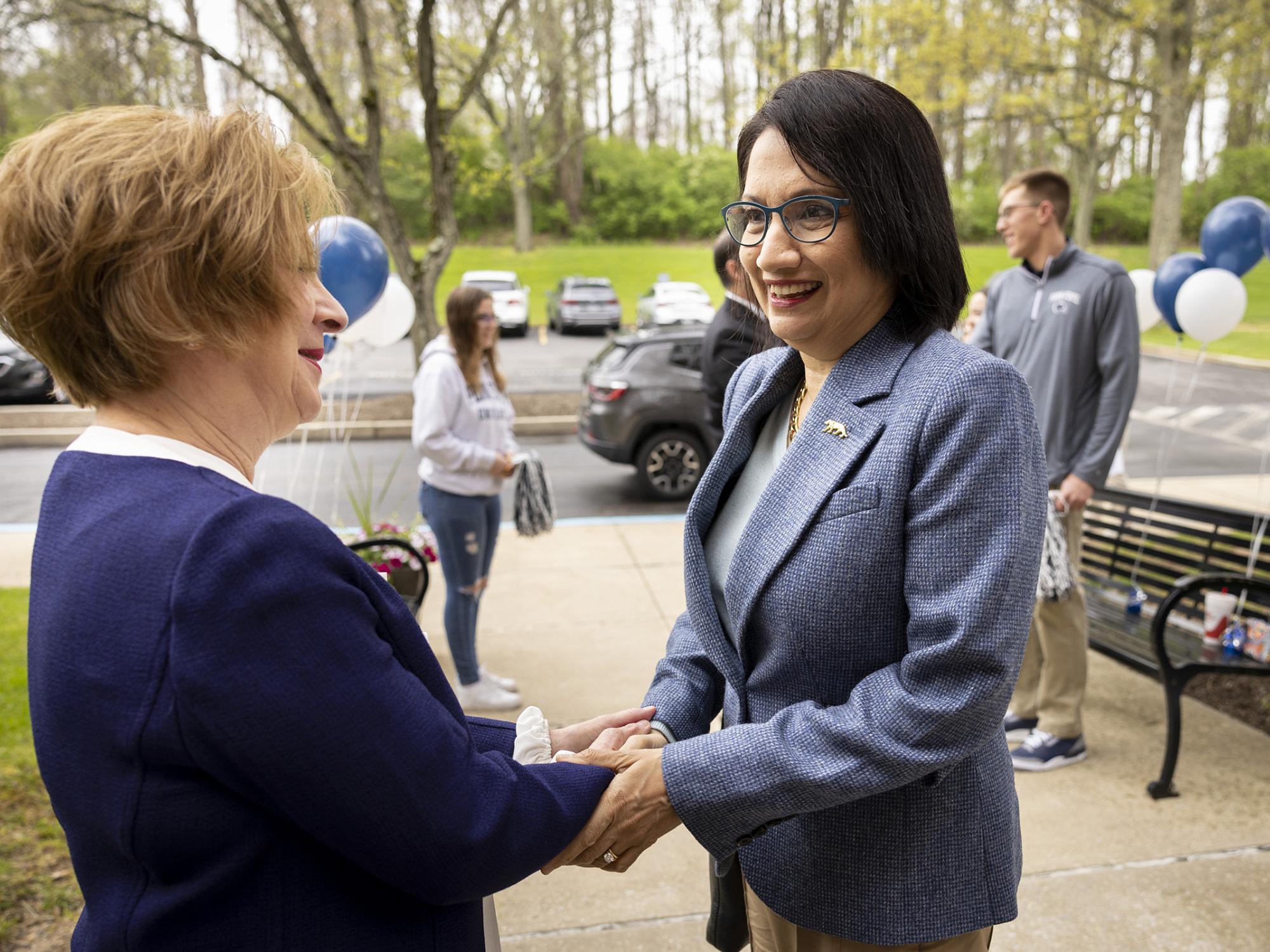 Two women shake hands.
