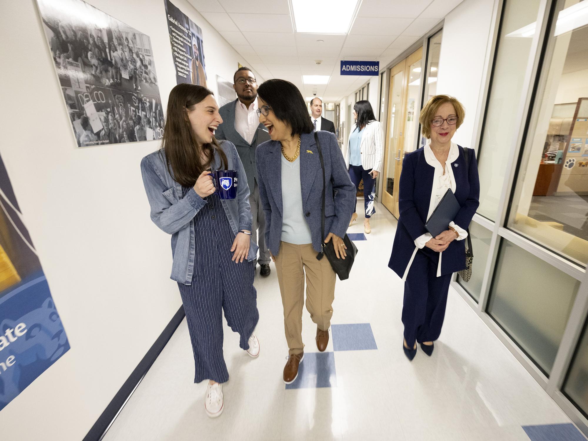 Three women walk down a hallway.