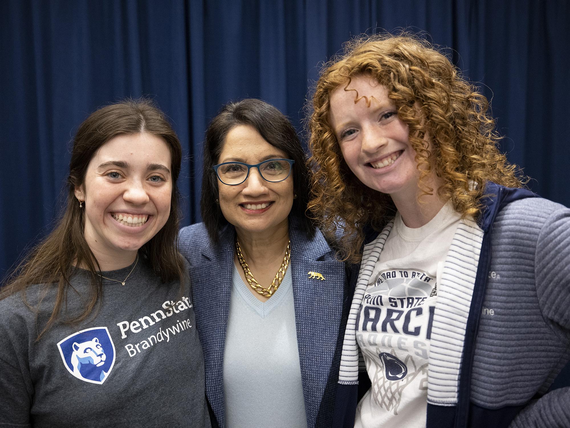 Three women stand together.