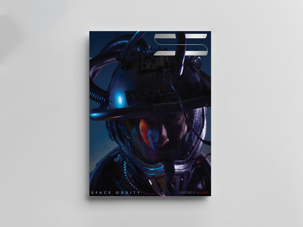 The cover of Space Oddity magazine featuring the closeup of a man's face in a space suit. 