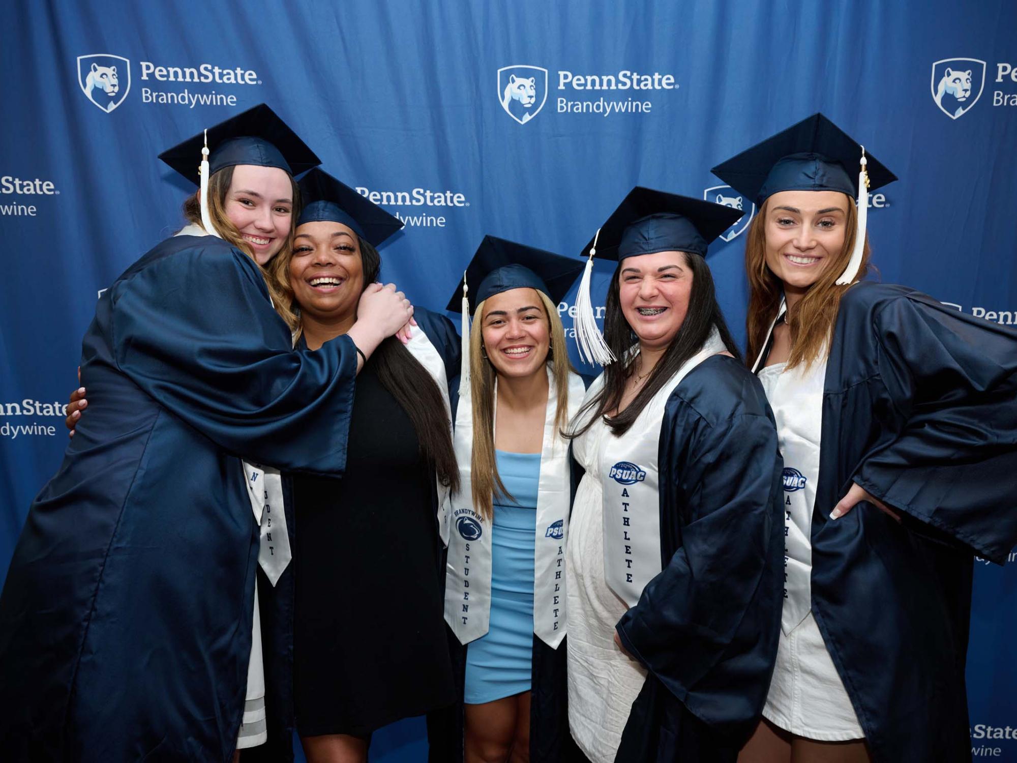 Five women stand in front of a banner.