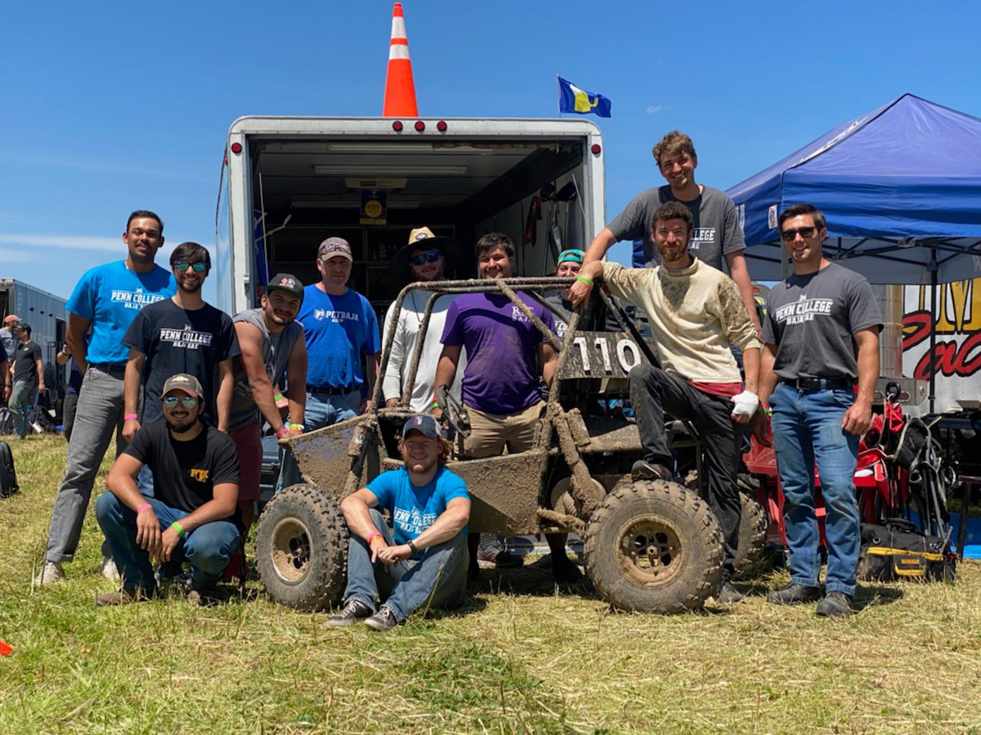The Baja SAE team poses for a photo with their car