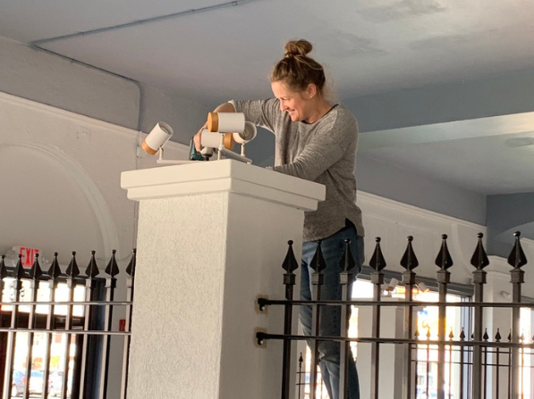 Founder Mel McDaniel adjusting a light fixture