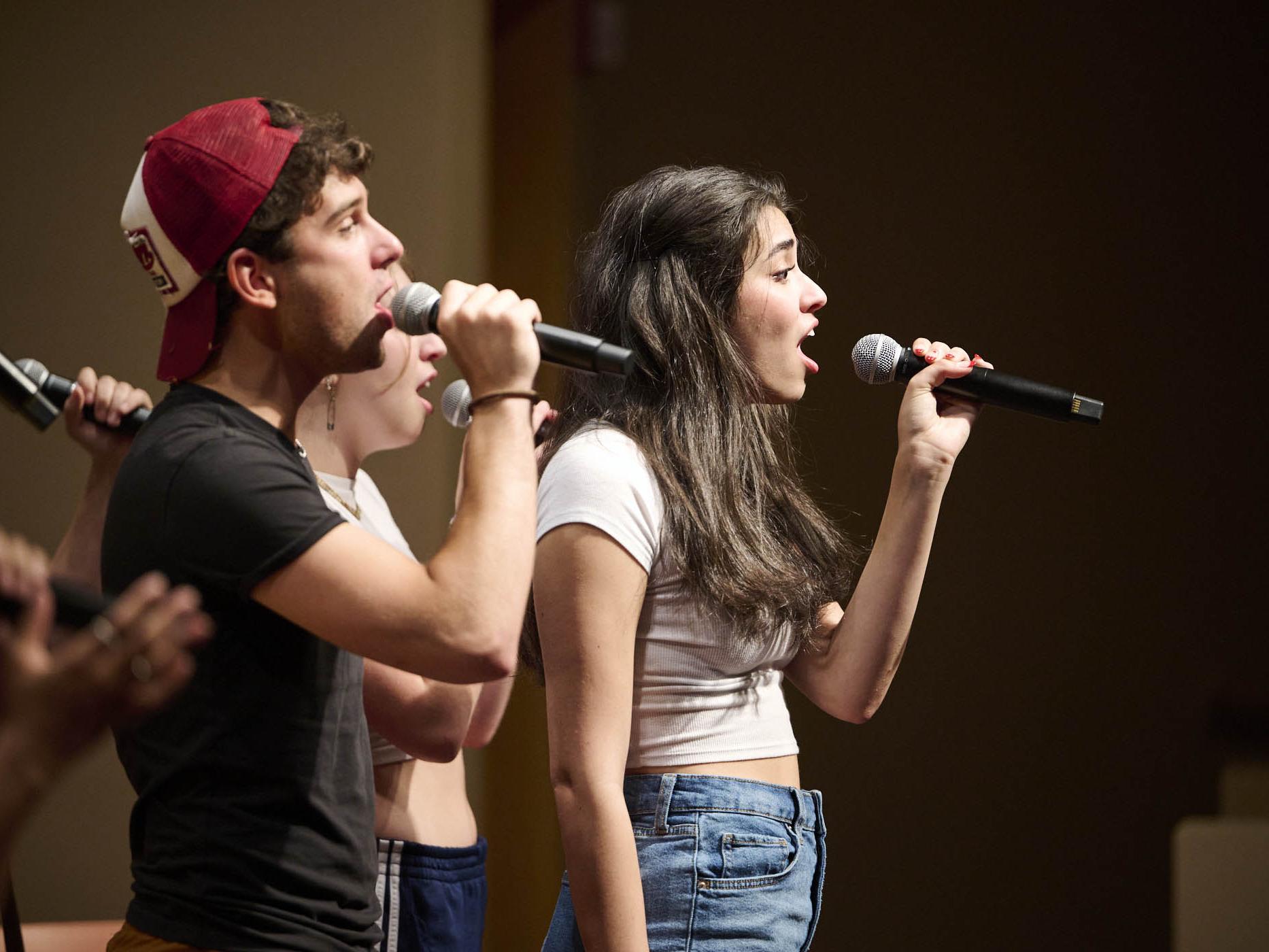 Cast members of the theatre show Results Will Vary stand shoulder to shoulder on a stage