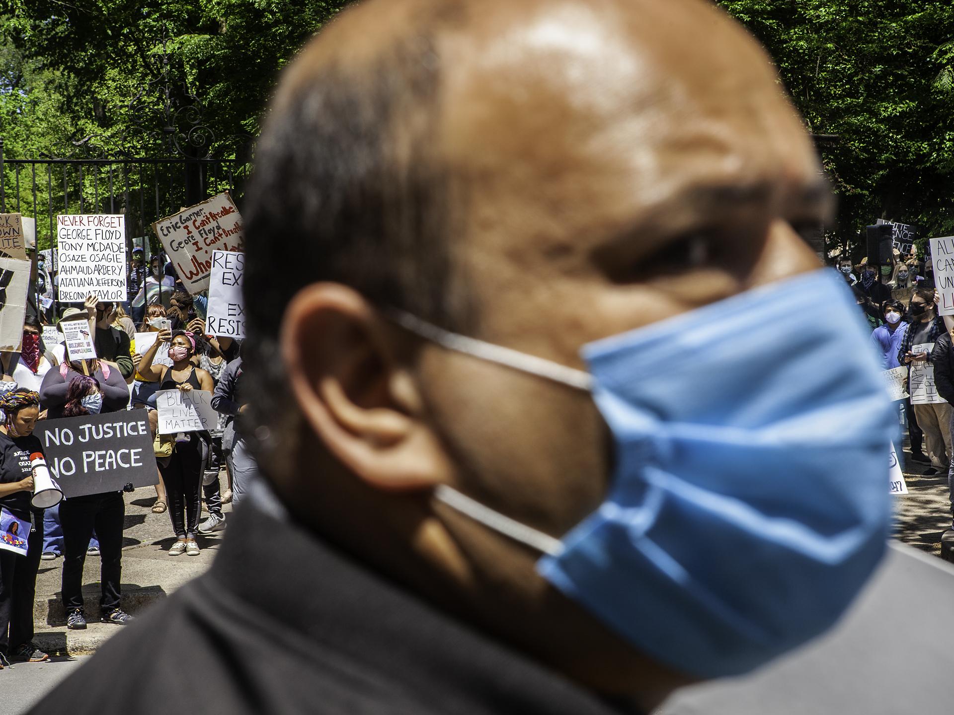 Photo of a protest with a man in a face mask