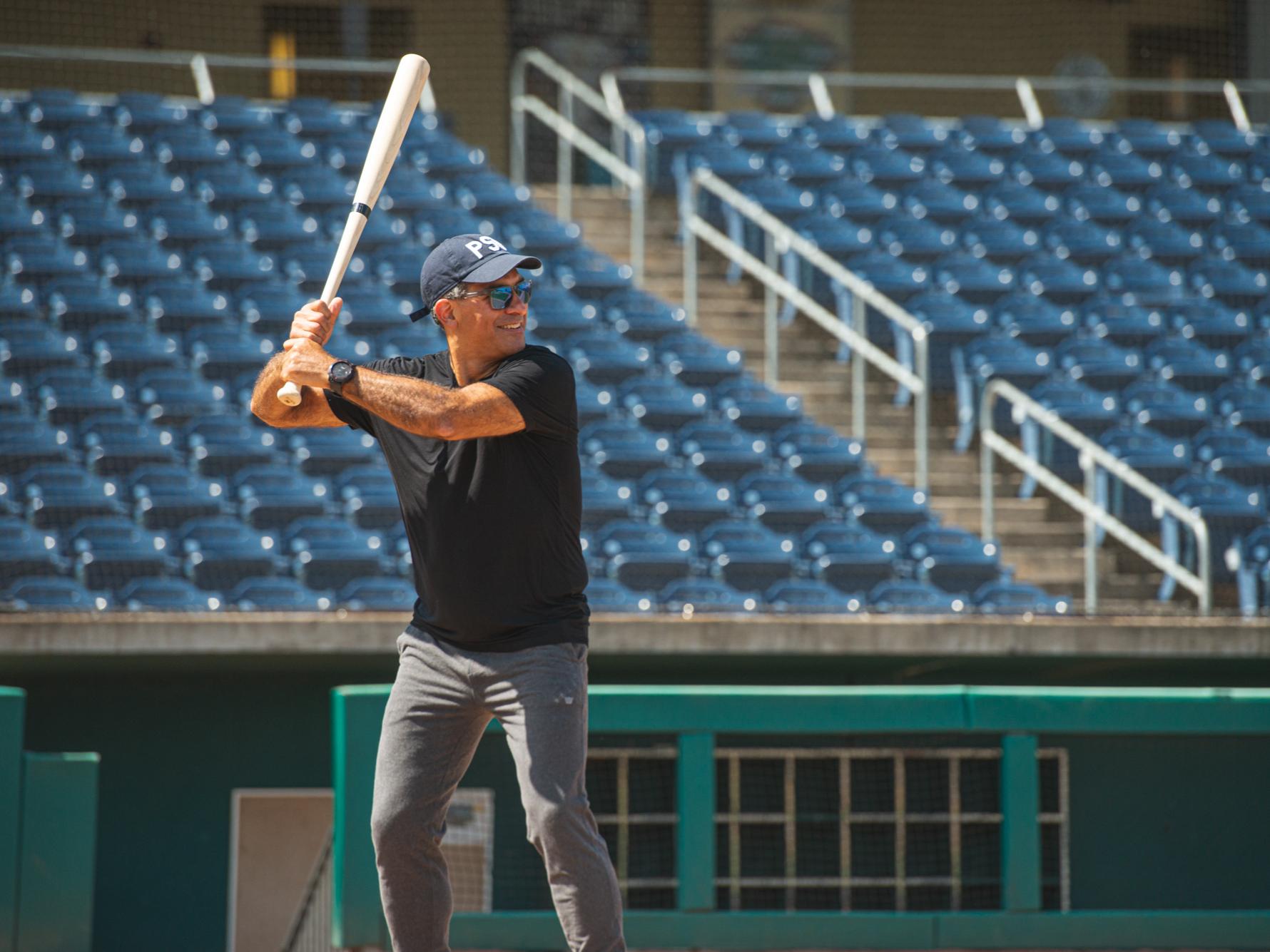 Justin Schwartz, Harold and Inge Marcus Dean in the College of Engineering, holds a baseball at home plate inside a baseball stadium.