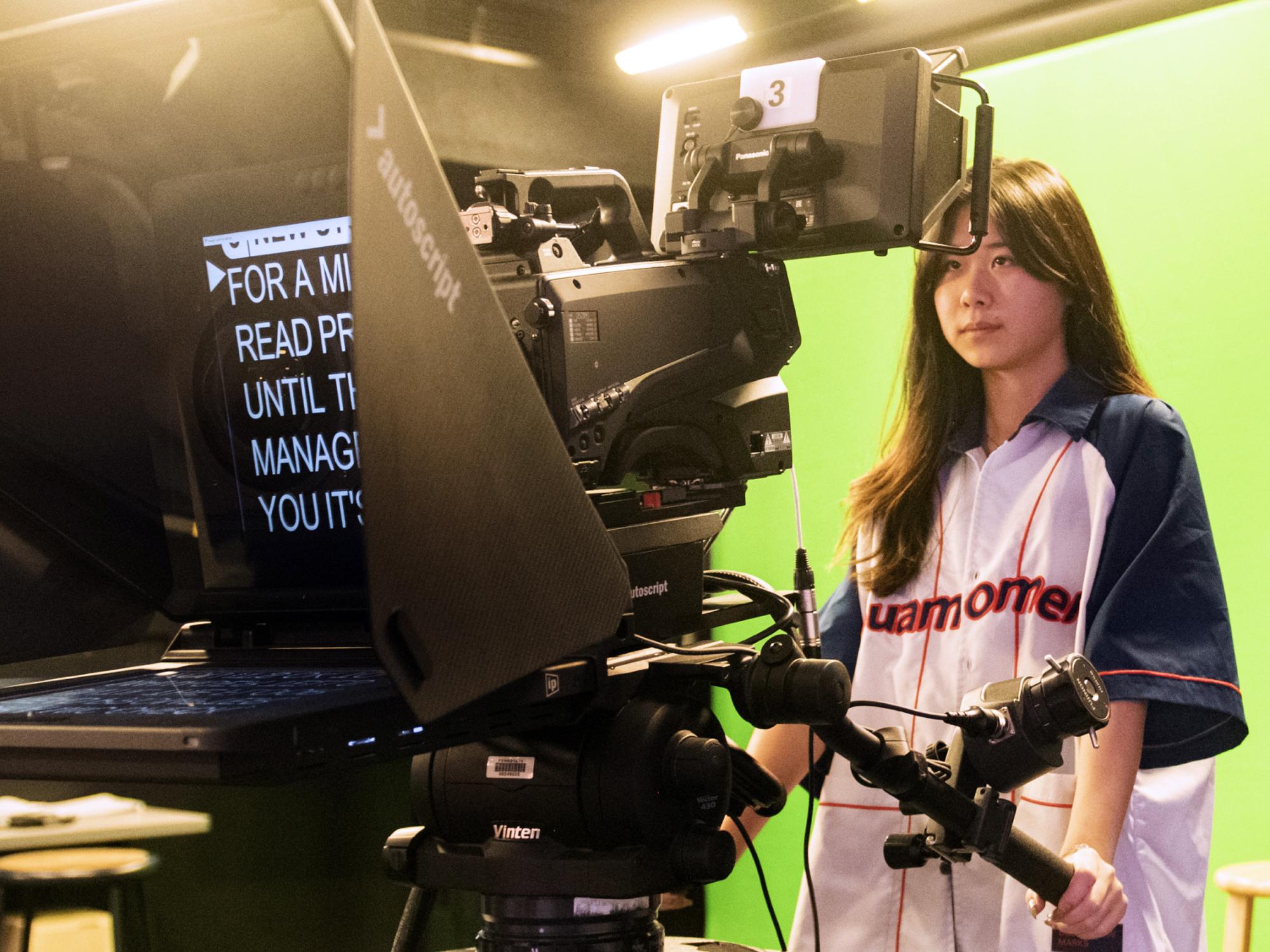 student in COMM 283 running a studio camera