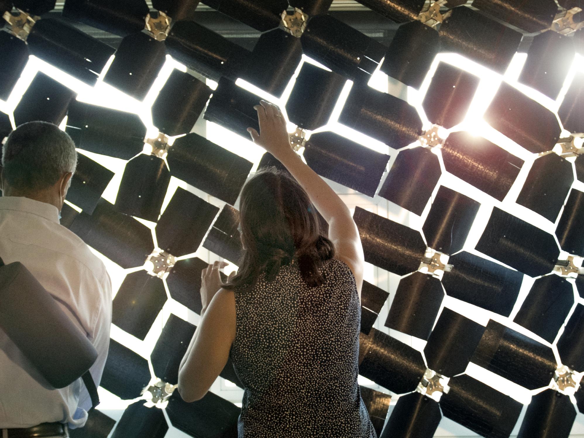backs of man and woman adjusting blades of window shade