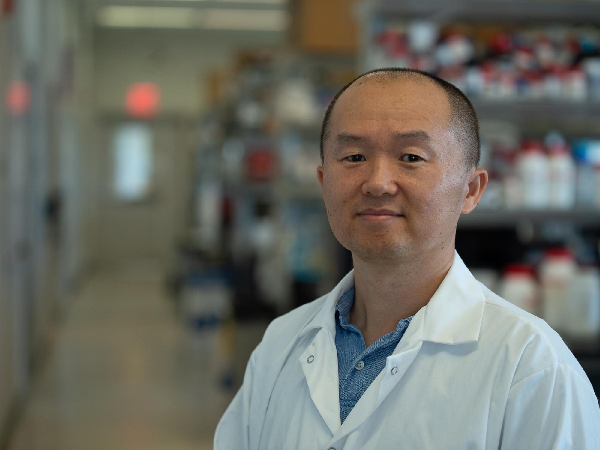 A portrait of a person wearing a white lab coat.