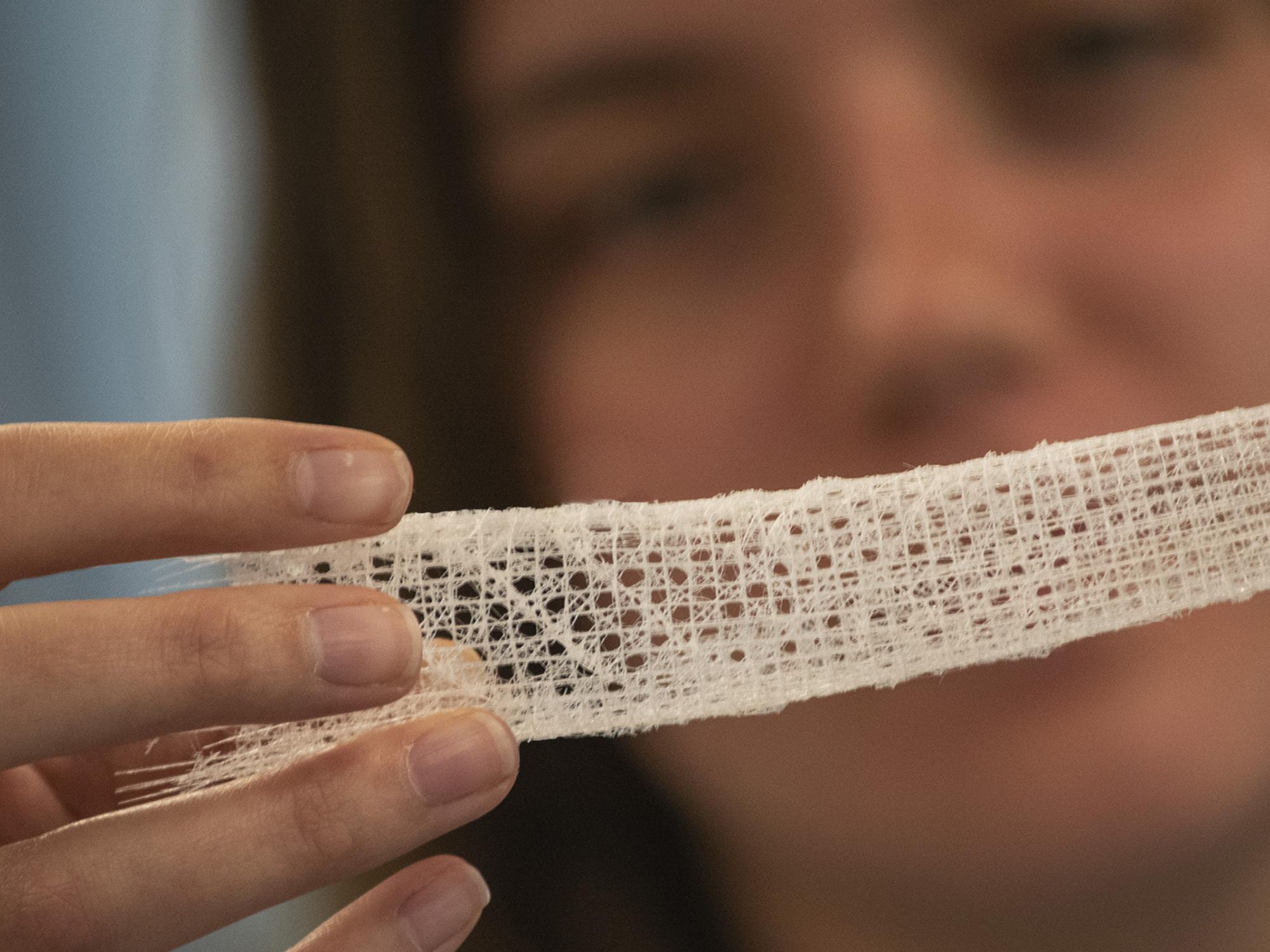 Woman out of focus in background looking at a closeup of a sample