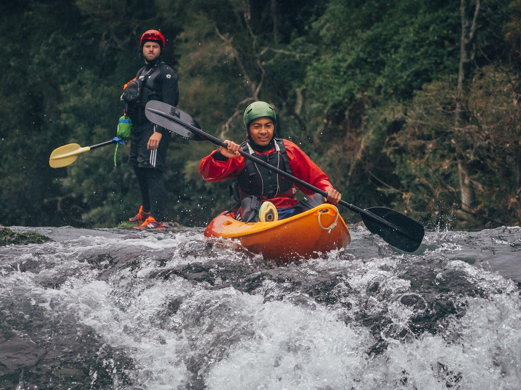 Outward Bound New Zealand student beginning to kayak over a large rapid
