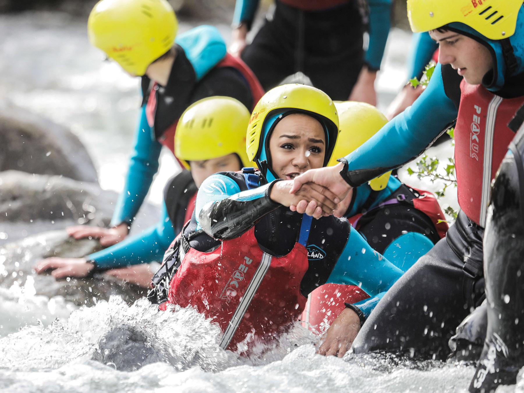 Outward Bound students in rough water helping each other