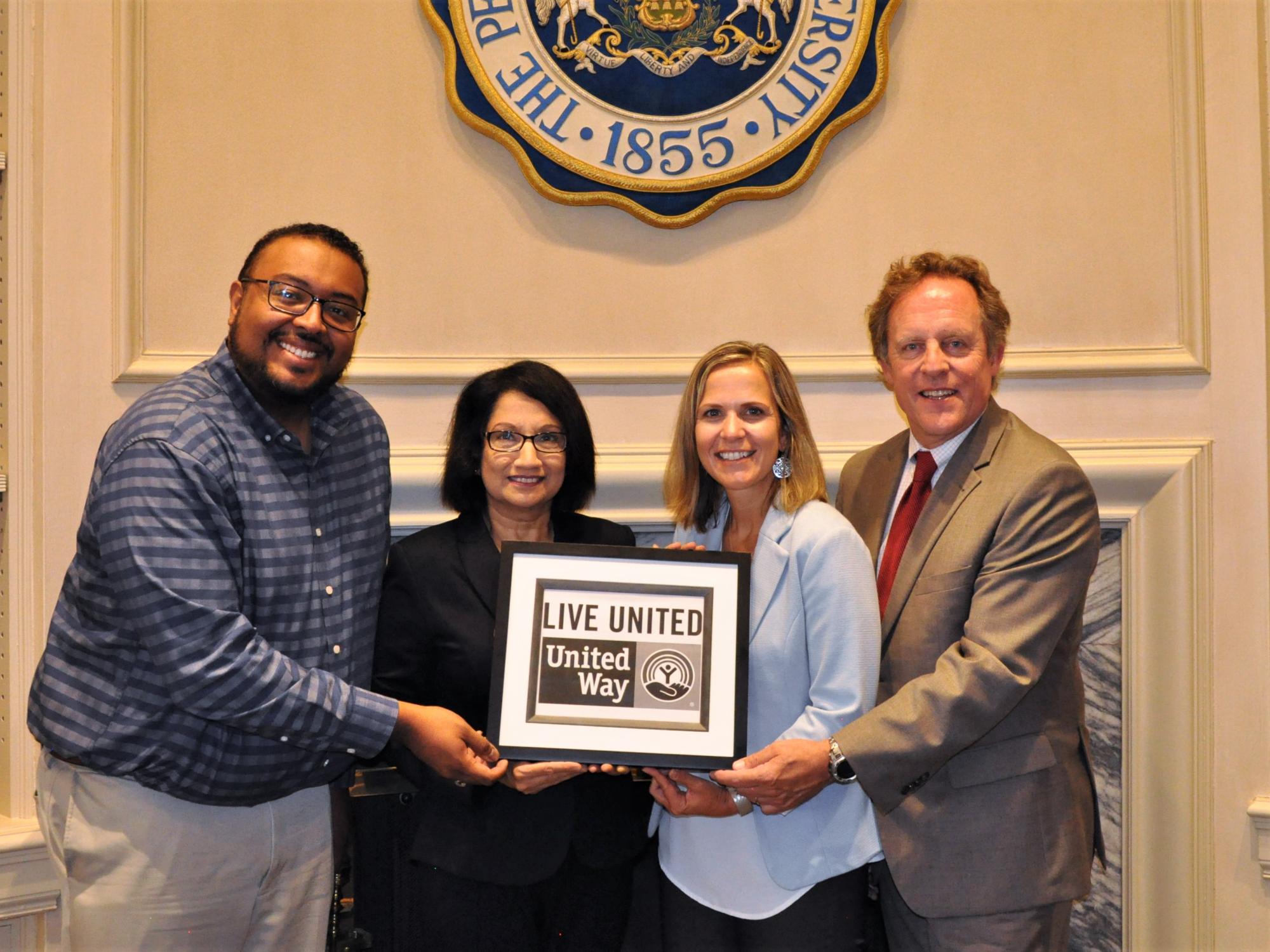 Penn State's leadership, the leadership of the Penn State United Way Campaign, and the leadership of the Centre County Untied Way jointly hold a "Live United" sign