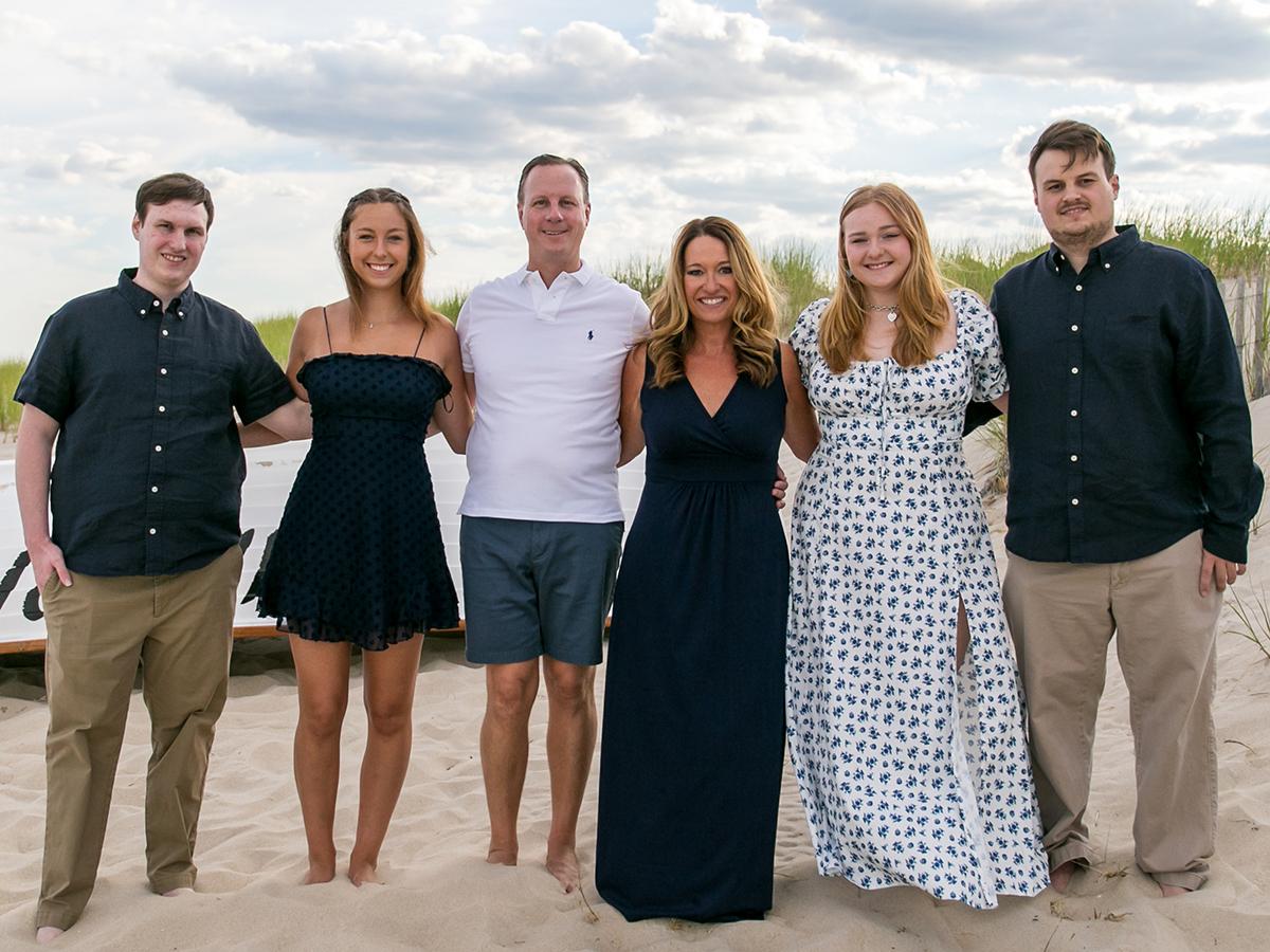 A photo of the Gido Family standing on the beach.