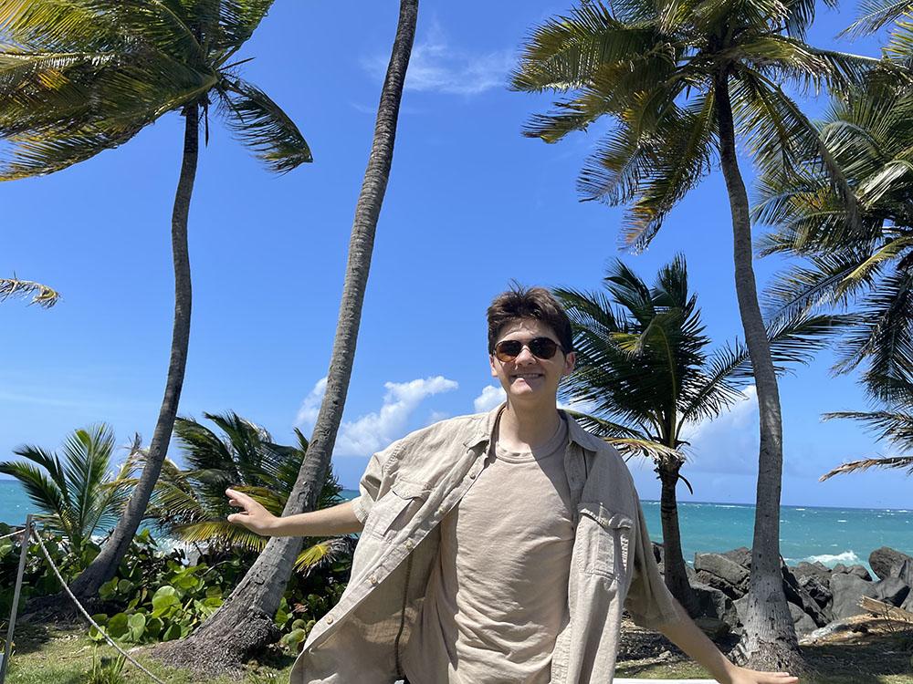 Caden Vitti poses in front of palm trees in Condado, Puerto Rico, which he visited after work.