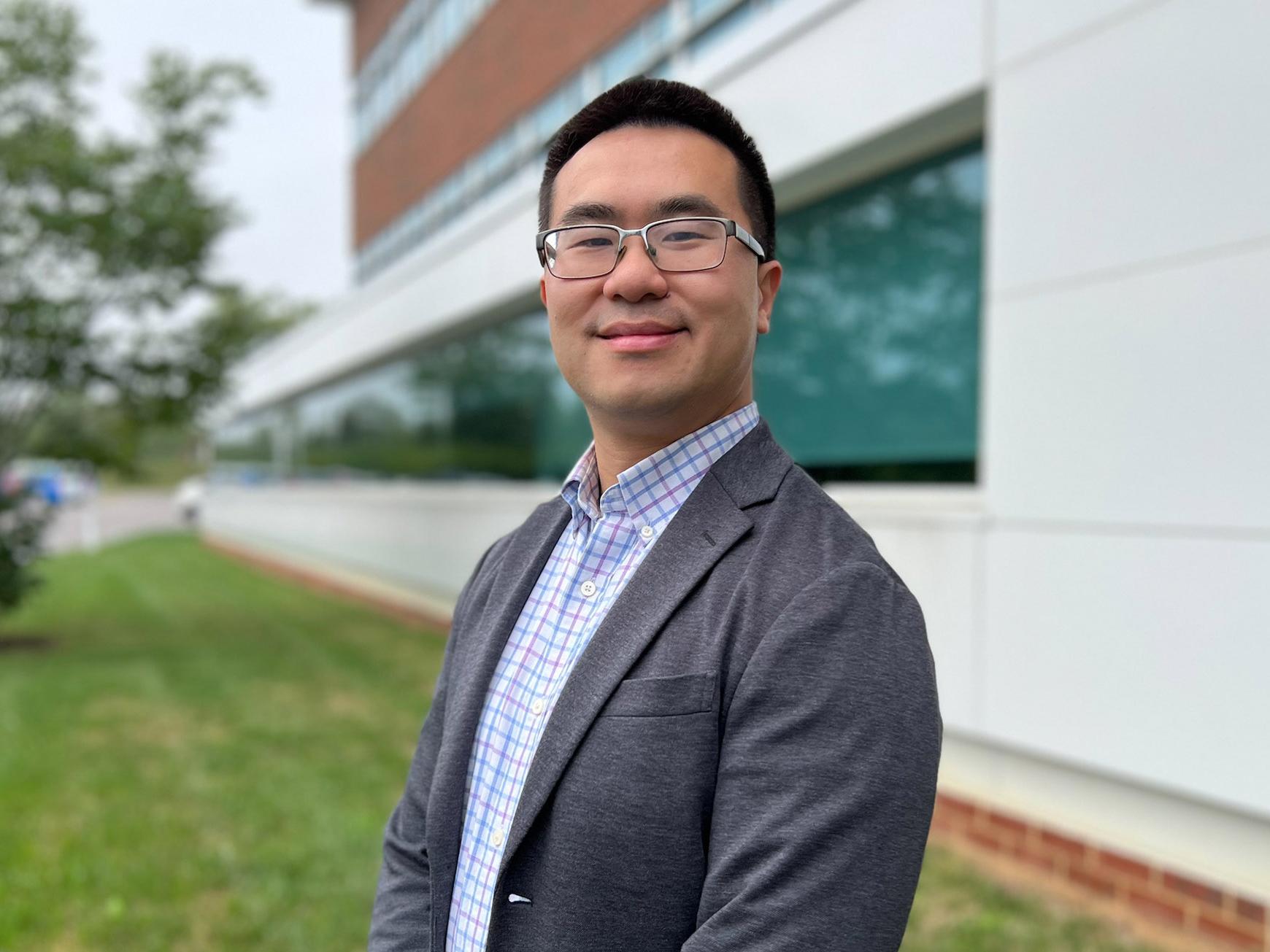 Julian Fung stands in front of the Outreach Building